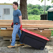 Photo of CRAFTSMAN rolling bin CMXXPBP50GTW with red lid, pulled outdoors at a work site.